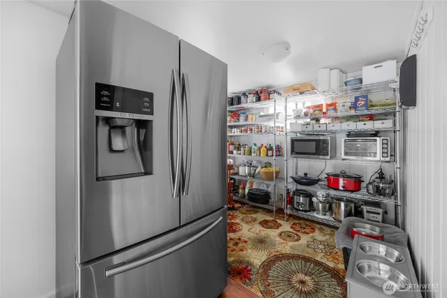 a kitchen with stainless steel appliances a refrigerator and a wooden floor