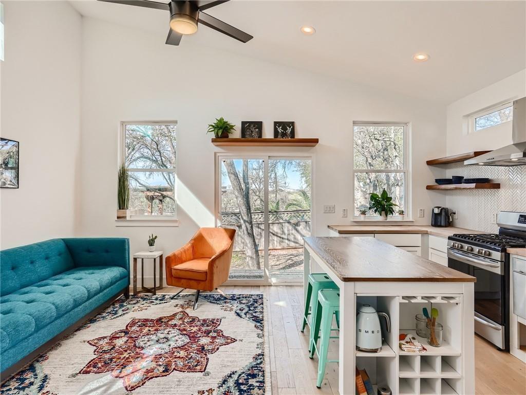 1614 Elmira Road Austin, TX 78721 - Photo 2 of 23 Vaulted ceilings and wide-plank wood flooring create an open, airy living space with a contemporary kitchen.