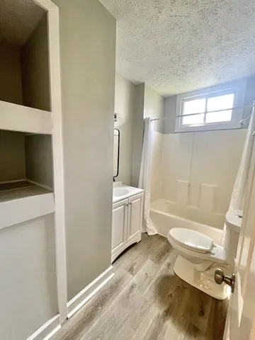 a bathroom with a sink a toilet a mirror and shower