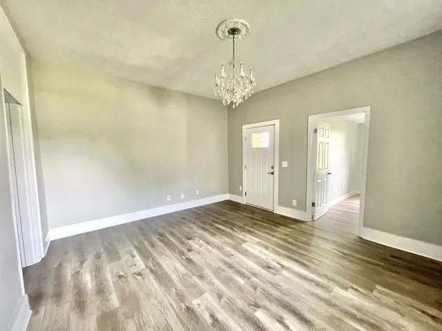 a view of an empty room with wooden floor