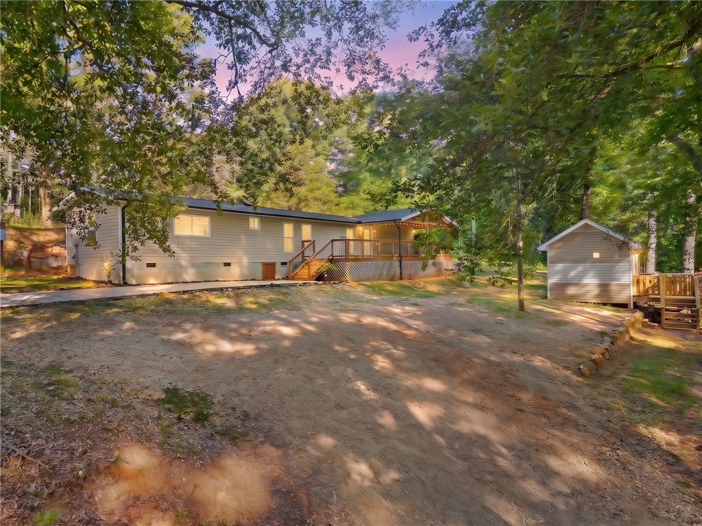 217 Old River Road Pelzer, SC 29669 - Photo 34 of 34 Mature trees frame a charming home featuring a spacious wooden deck and separate outbuilding.