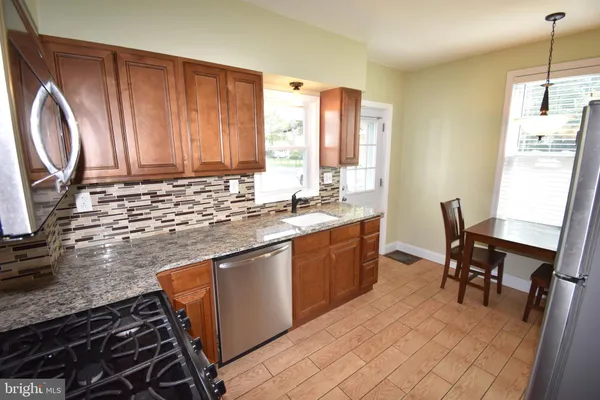 a kitchen with stainless steel appliances granite countertop a sink stove and cabinets