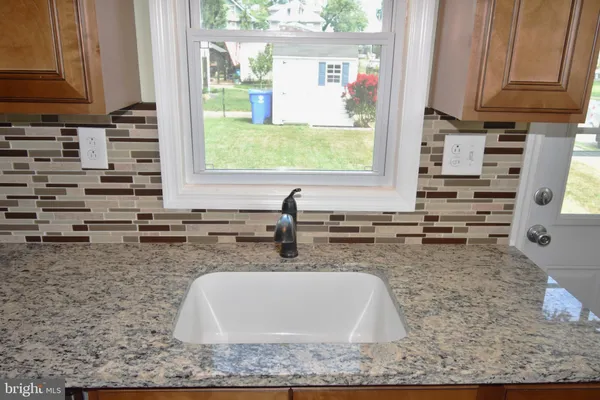 a kitchen with sink a window and cabinets