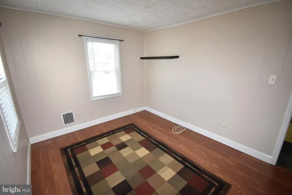 a view of a room with wooden floor and a window