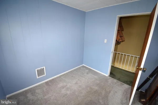 a view of a hallway with wooden floor and stairs