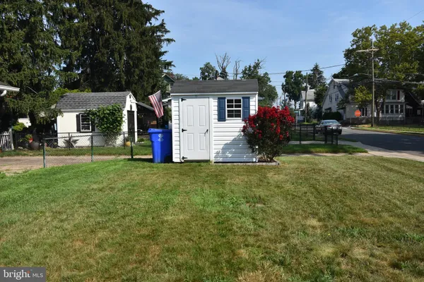 a view of a house with a big yard and large tree