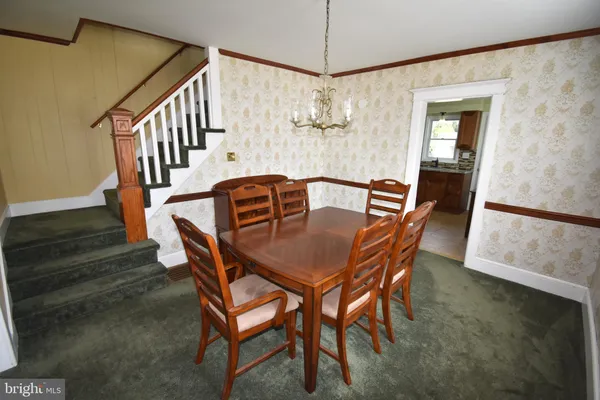 a dining room with furniture a chandelier and wooden floor