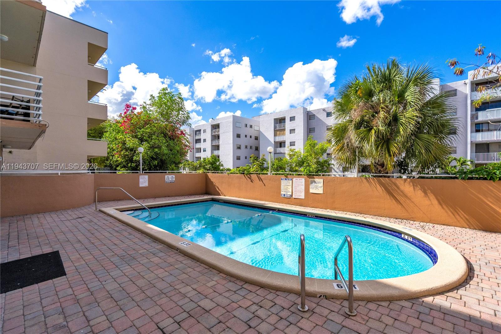 8050 Northwest 8th Street, Unit 305 Miami, FL 33126 - Photo 19 of 25 a view of a swimming pool with a lounge chairs