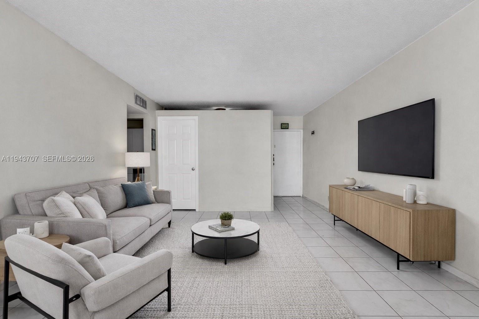 8050 Northwest 8th Street, Unit 305 Miami, FL 33126 - Photo 3 of 25 a living room with furniture and a flat screen tv