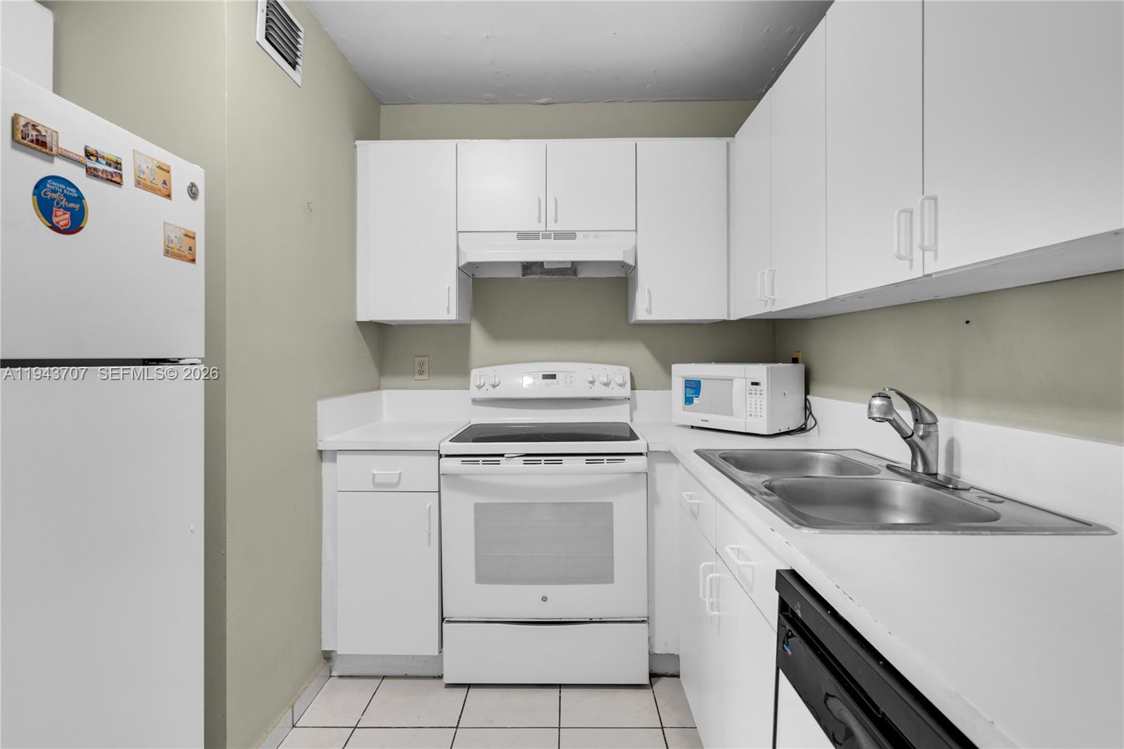 8050 Northwest 8th Street, Unit 305 Miami, FL 33126 - Photo 5 of 25 a kitchen with a stove top oven and cabinets