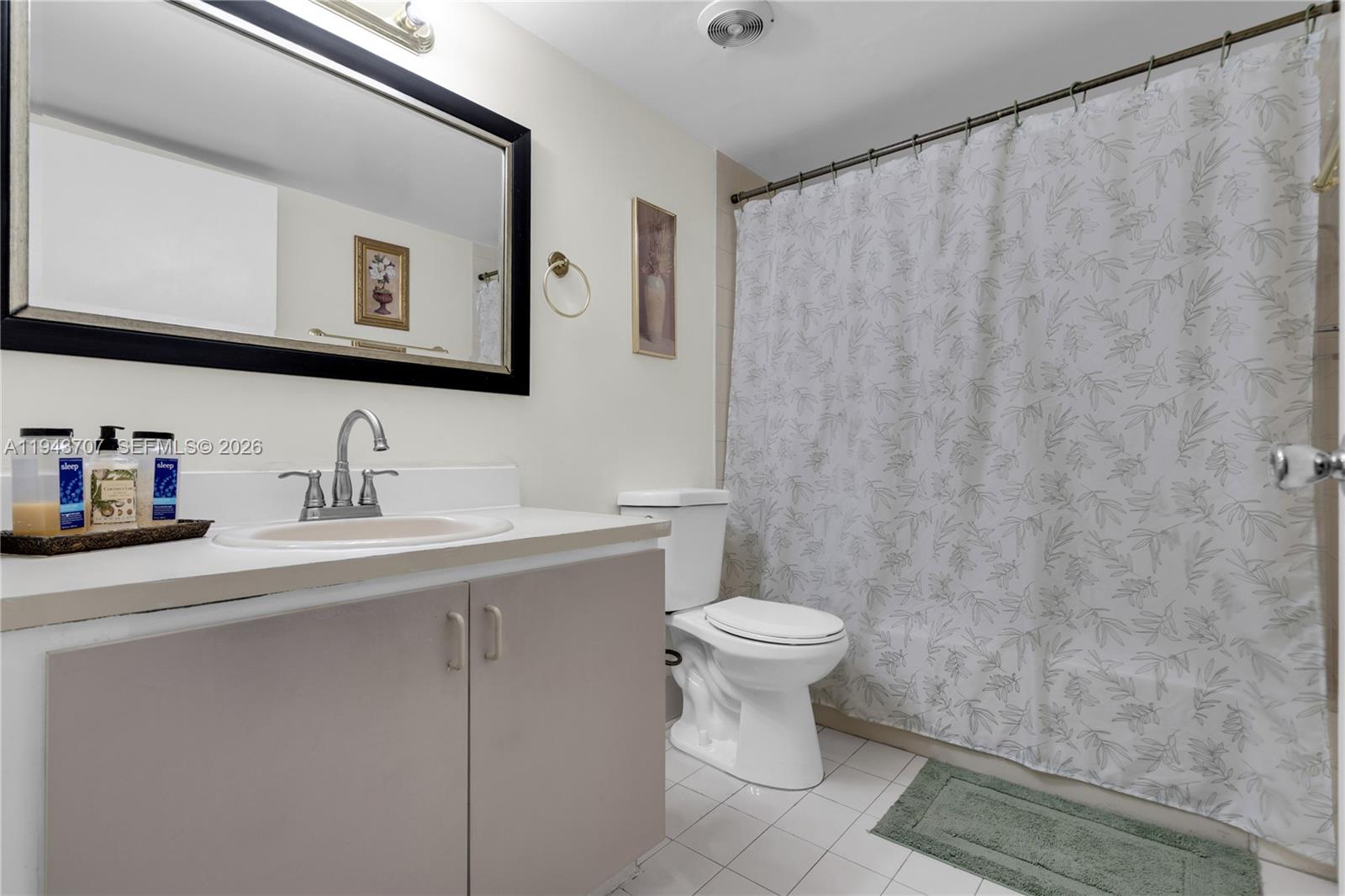 8050 Northwest 8th Street, Unit 305 Miami, FL 33126 - Photo 10 of 25 a bathroom with a sink a toilet and mirror