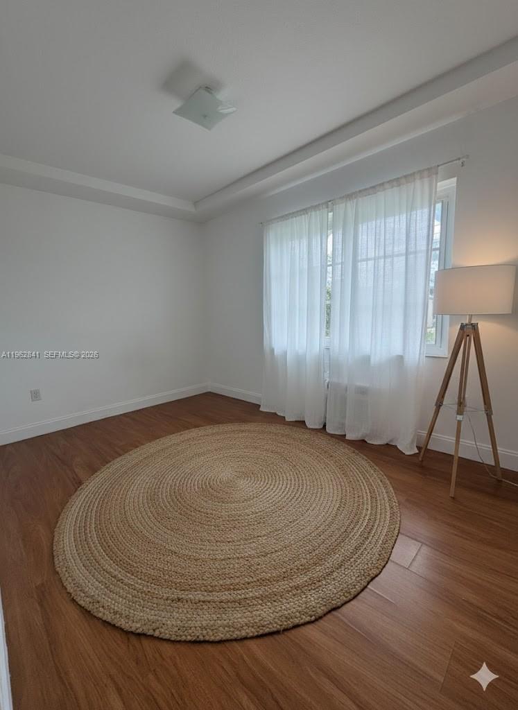6941 Bay Drive, Unit A1 Miami Beach, FL 33141 - Photo 6 of 10 an empty room with wooden floor and windows