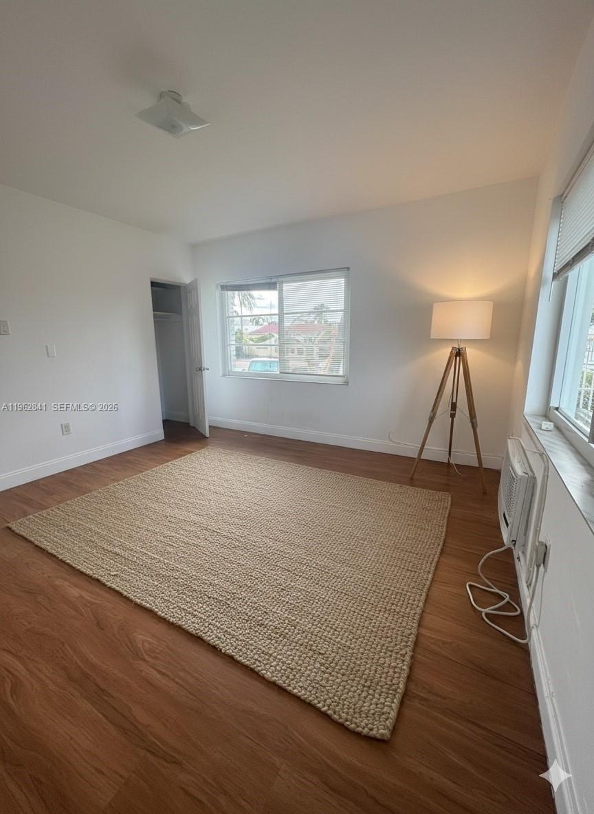 6941 Bay Drive, Unit A1 Miami Beach, FL 33141 - Photo 8 of 10 an empty room with wooden floor and windows