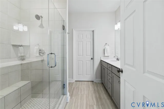 a bathroom with a double vanity sink a toilet and shower