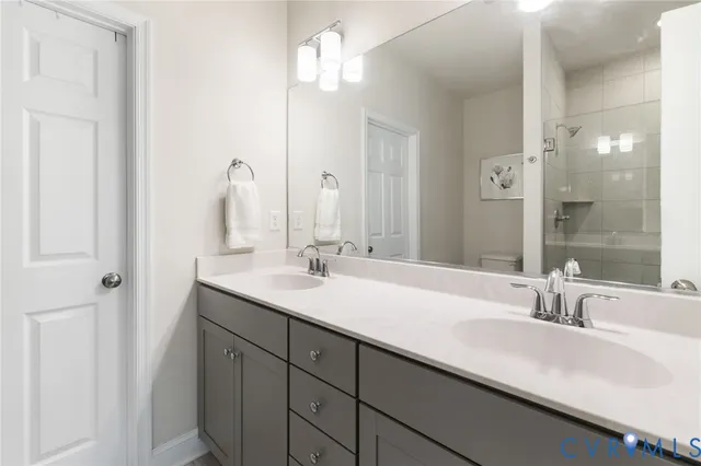 a bathroom with double vanity sinks and a mirror