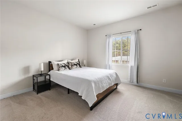 a bed sitting in a bedroom next to a window