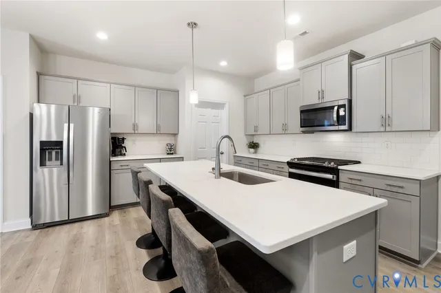 a kitchen with a sink a stove a refrigerator and a microwave