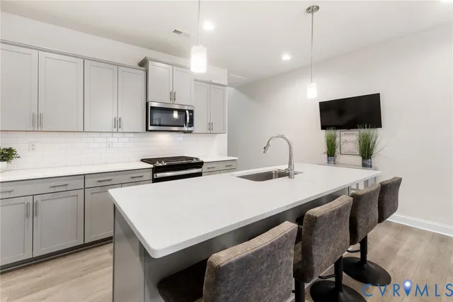 a kitchen with a sink and a stove top oven with wooden floor