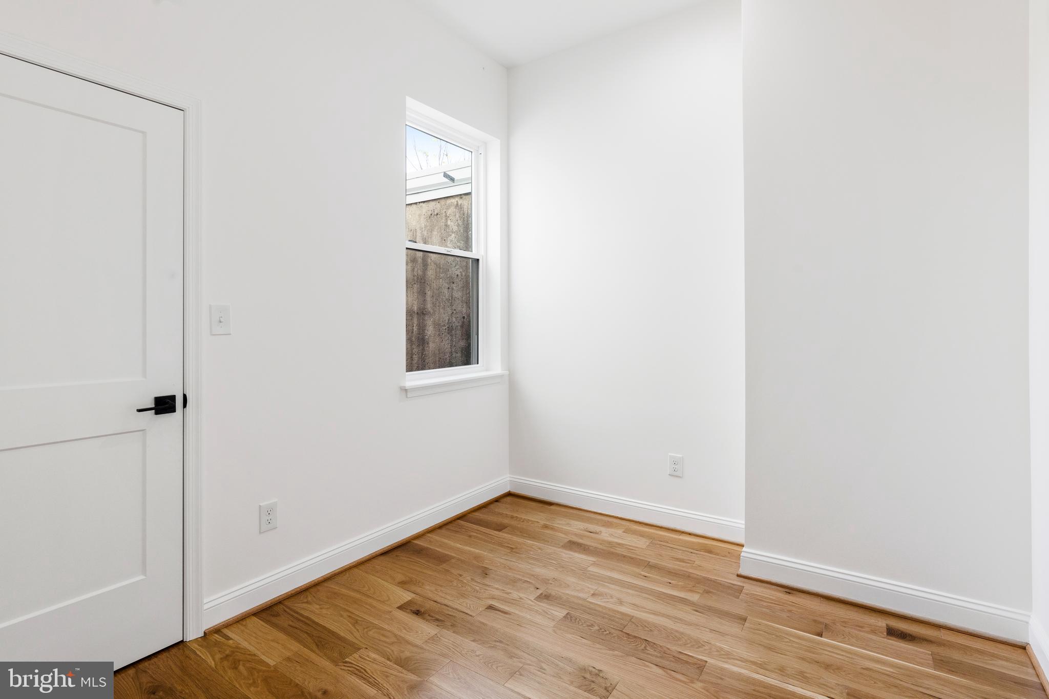 934 Harlem Avenue Baltimore, MD 21217 - Photo 13 of 28 a view of an empty room with wooden floor and a window
