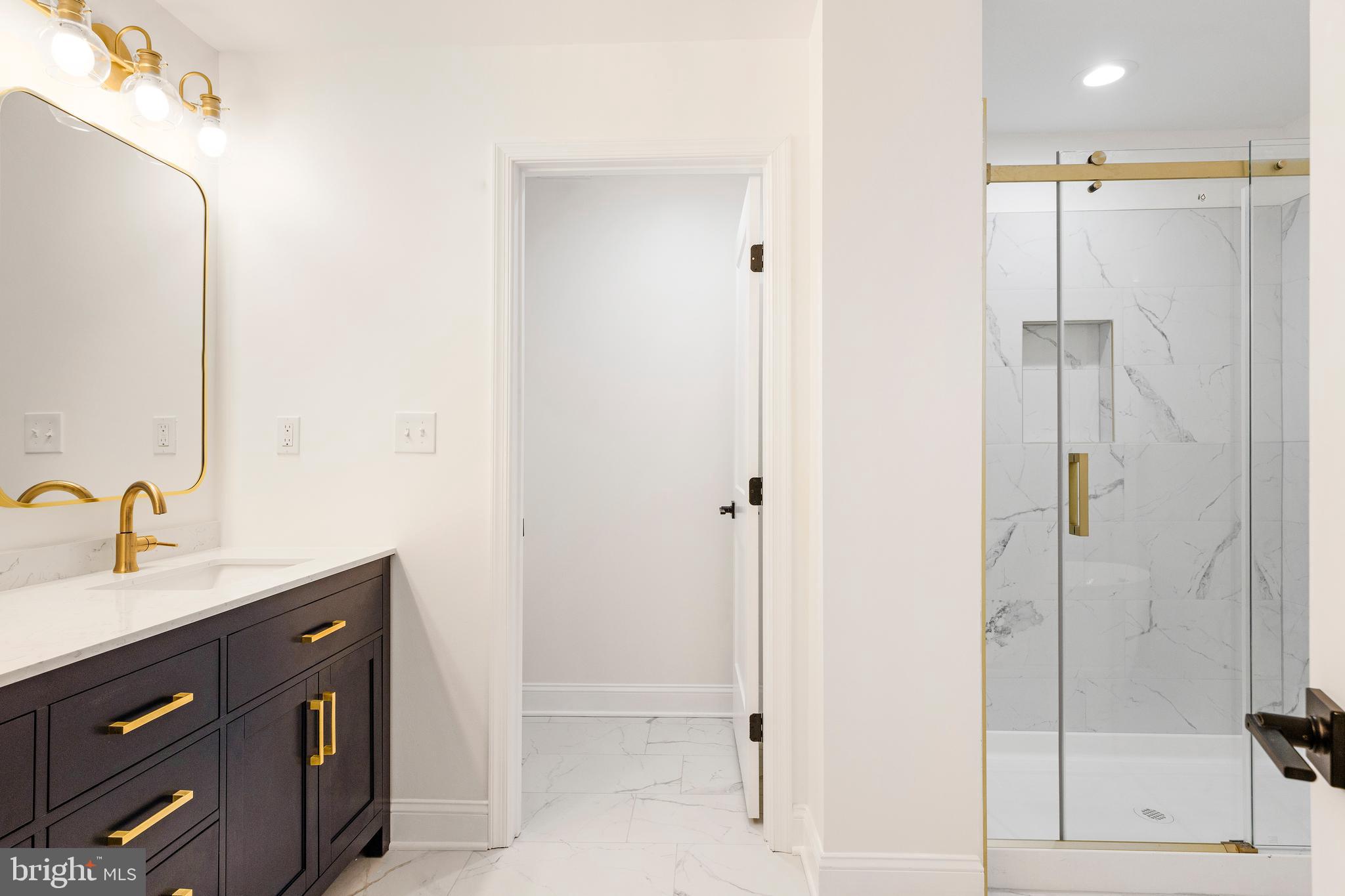 934 Harlem Avenue Baltimore, MD 21217 - Photo 16 of 28 a bathroom with a double vanity sink a mirror and shower