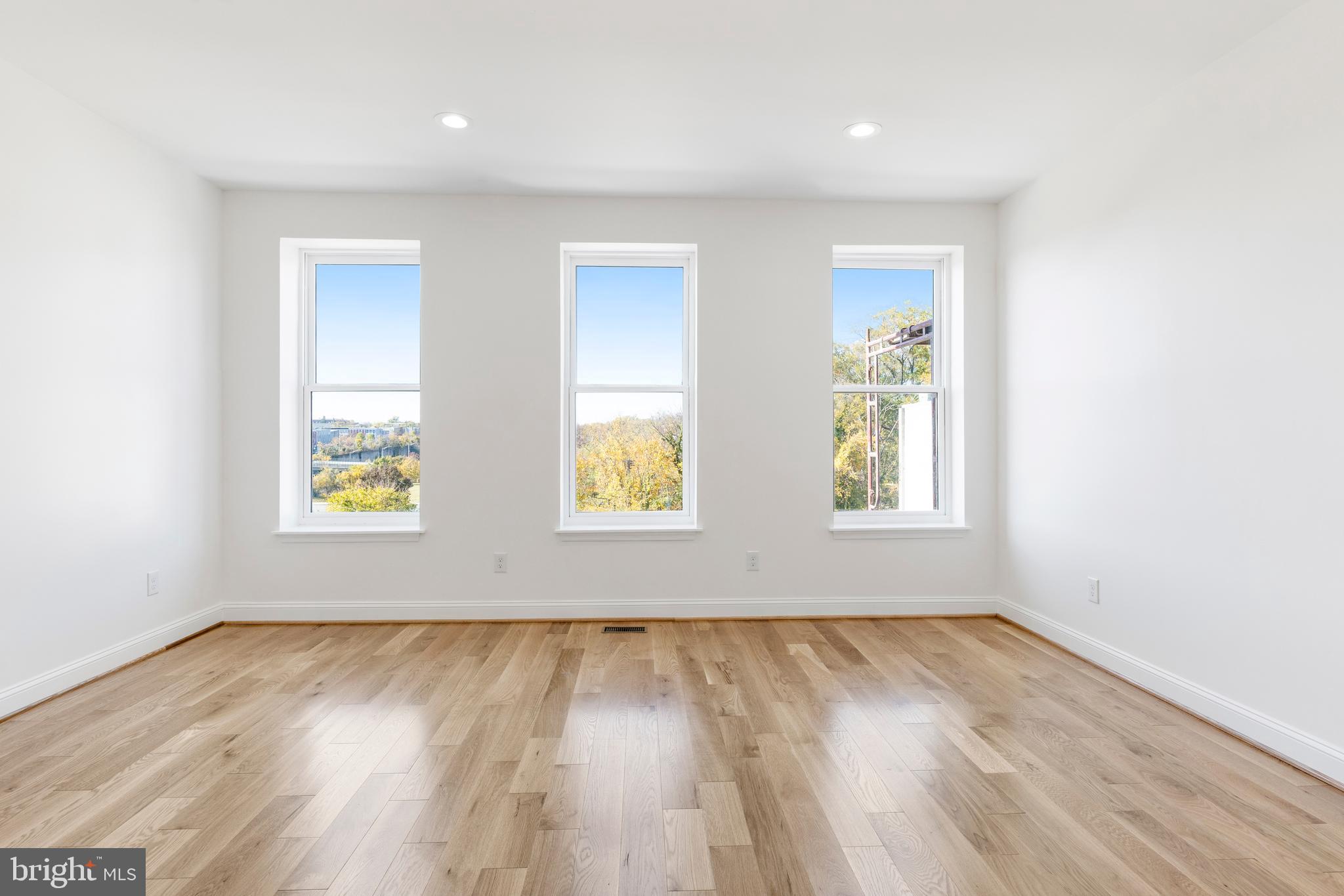 934 Harlem Avenue Baltimore, MD 21217 - Photo 27 of 28 an empty room with wooden floor and windows