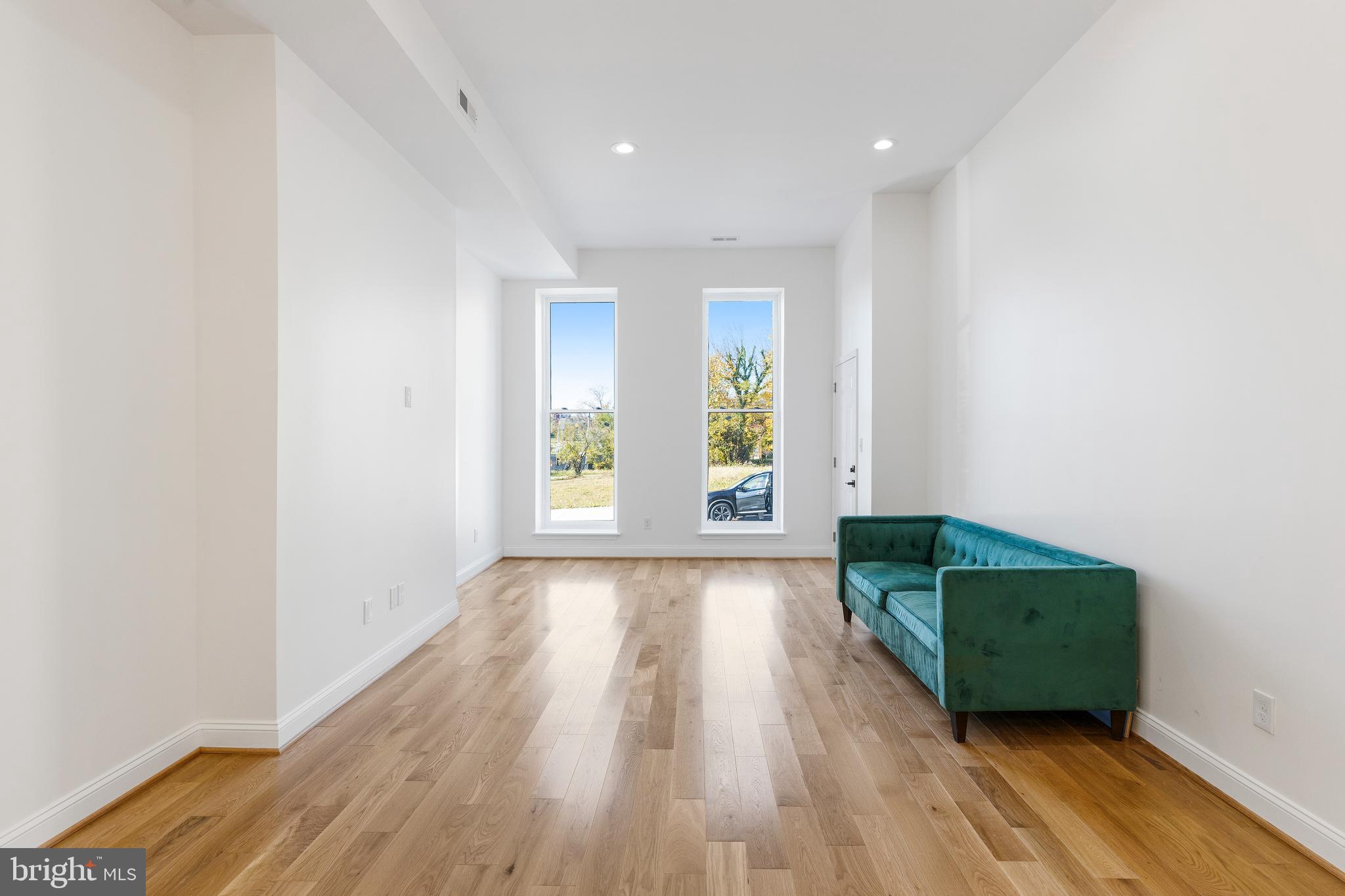 934 Harlem Avenue Baltimore, MD 21217 - Photo 4 of 28 an empty room with wooden floor and windows