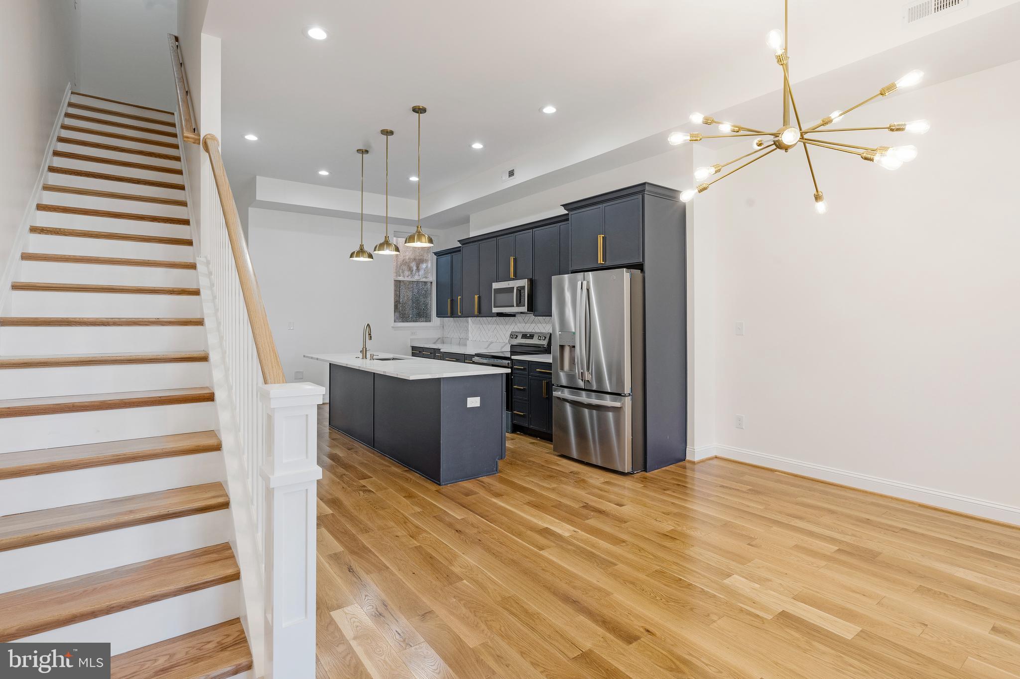 934 Harlem Avenue Baltimore, MD 21217 - Photo 5 of 28 a kitchen with stainless steel appliances kitchen island a refrigerator sink and cabinets