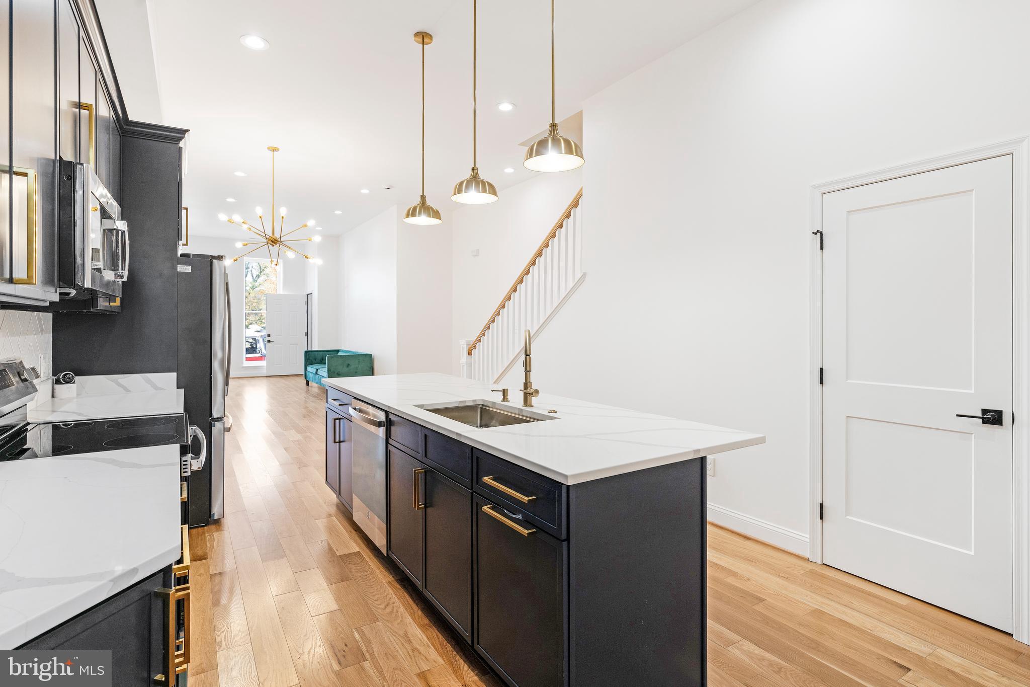 934 Harlem Avenue Baltimore, MD 21217 - Photo 9 of 28 a kitchen with a sink a stove and a wooden floor