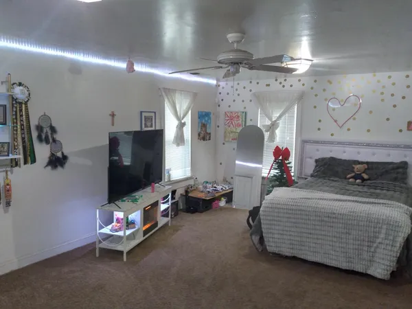 a bedroom with bed and a flat tv screen on the dresser