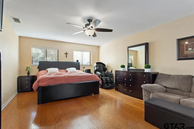 a spacious bedroom with a bed a couch and dresser