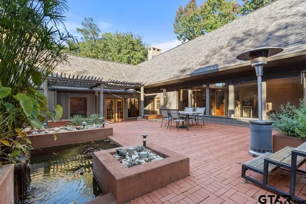 a view of a patio with couches table and chairs and potted plants