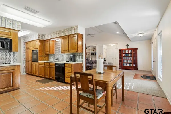 a kitchen with stainless steel appliances kitchen island granite countertop a stove a sink a dining table and chairs