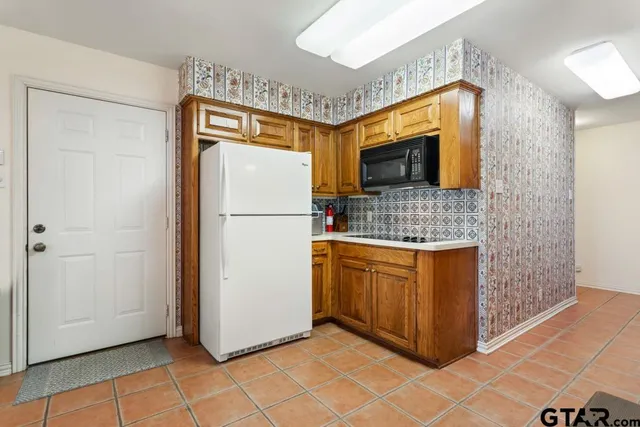 a kitchen with stainless steel appliances granite countertop a refrigerator and a sink