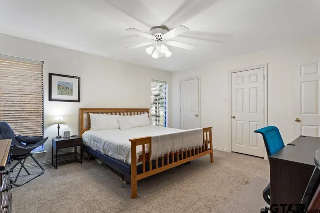 a spacious bedroom with a bed and a chandelier