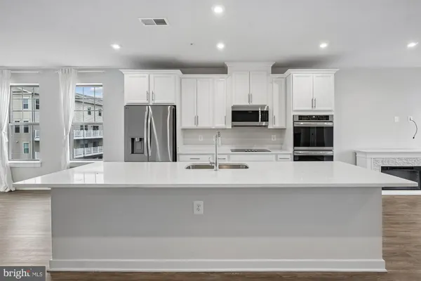 a view of kitchen with stainless steel appliances cabinets