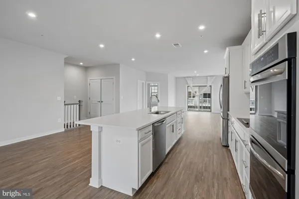 a large kitchen with stainless steel appliances a large counter top and a stove