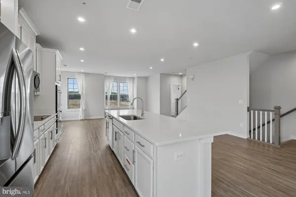 a kitchen with stainless steel appliances granite countertop a refrigerator a stove a sink and a refrigerator