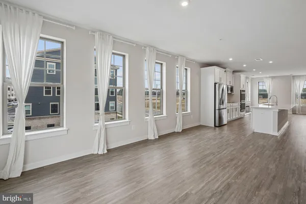 a view of a big room with wooden floor and windows