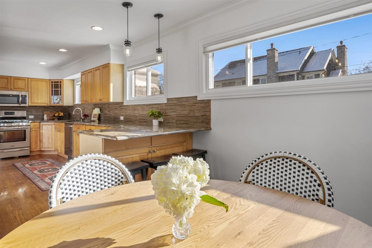 1821 George Court Glenview, IL 60025 - Photo 7 of 24 a kitchen with a sink dishwasher a dining table and chairs with wooden floor