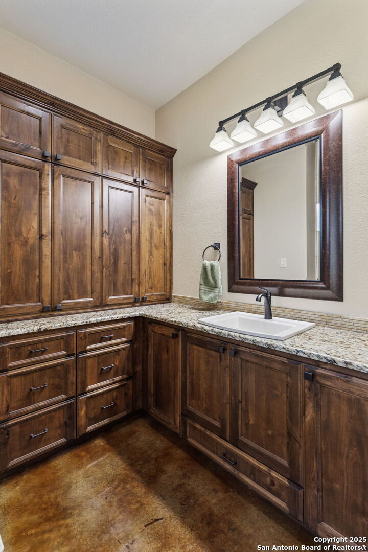 199 Shepherds Crook Helotes, TX 78023 - Photo 50 of 108 a bathroom with a granite countertop sink and mirror