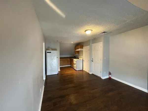 a view of empty room with wooden floor
