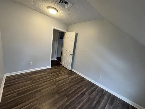a view of an empty room with wooden floor