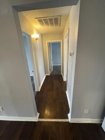 a view of a hallway with wooden floor