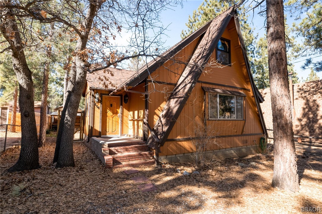 456 Riverside Avenue Sugarloaf, CA 92386 - Photo 1 of 19 a backyard of a house with large trees and outdoor seating