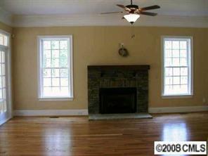 124 Streamwood Road, Unit 15 Troutman, NC 28166 - Photo 7 of 8 a view of an empty room with wooden floor and a fireplace