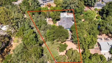 an aerial view of residential house with parking and yard