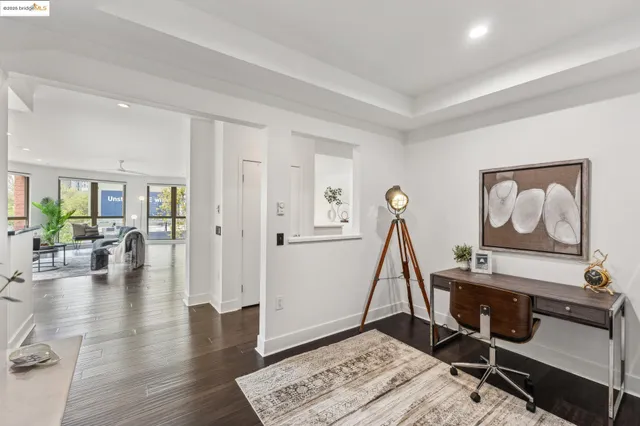 a living room with lots of furniture wooden floor and a large window