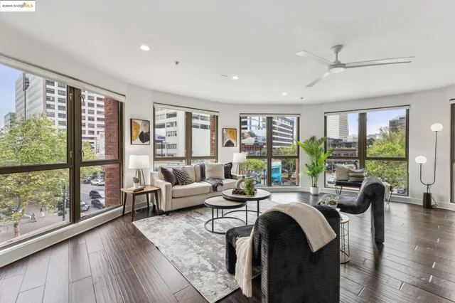 a living room with furniture potted plant and a large window