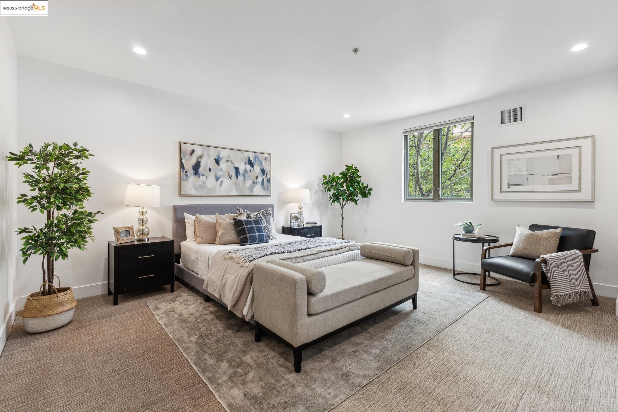 438 West Grand Avenue, Unit 420 Oakland, CA 94612 - Photo 29 of 58 a spacious bedroom with a bed and a couch