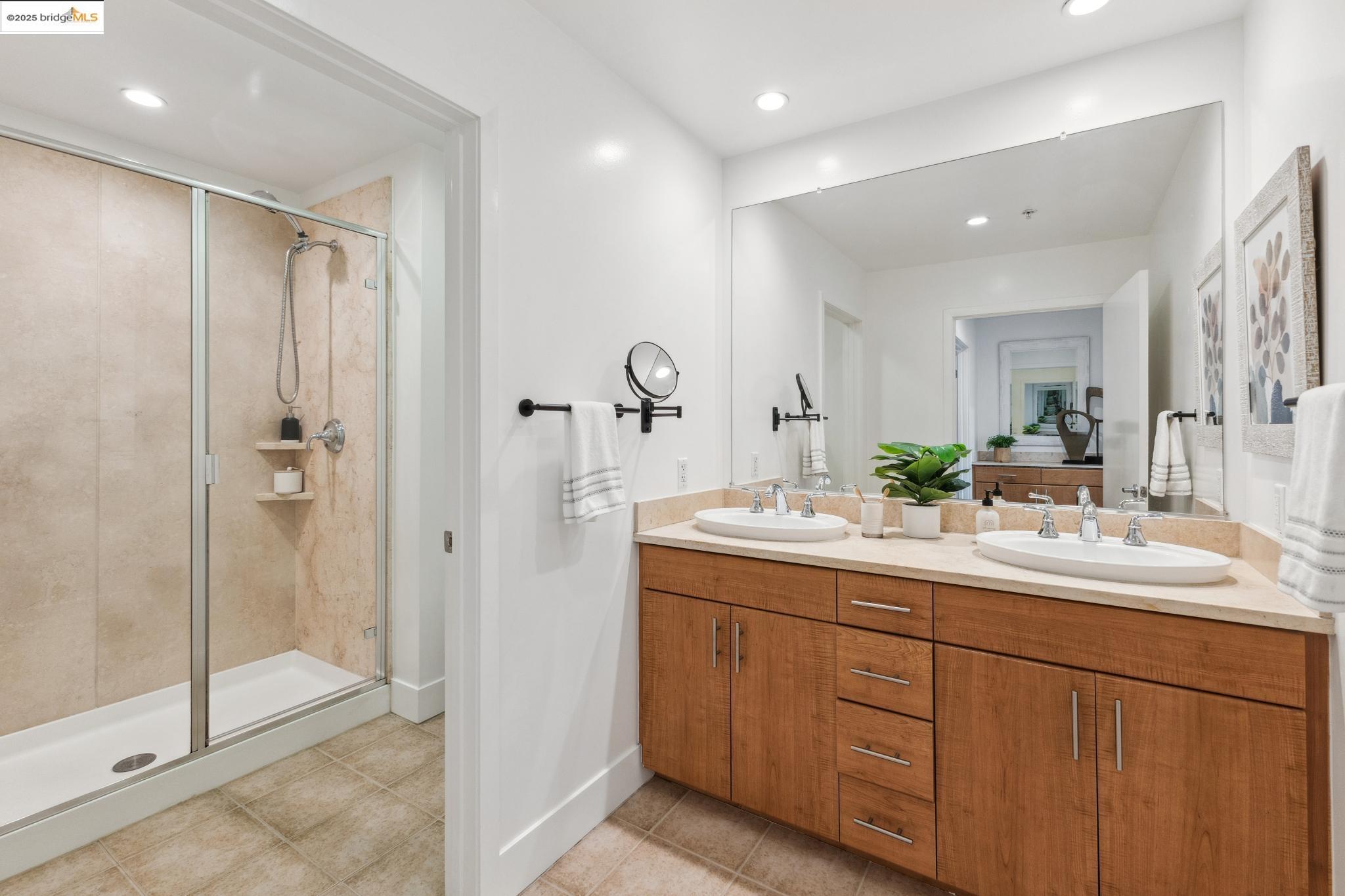 438 West Grand Avenue, Unit 420 Oakland, CA 94612 - Photo 33 of 58 a bathroom with a double vanity sink mirror and shower